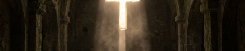 Sunlight beams through a cross-shaped window onto a stone altar in an ancient monastery.