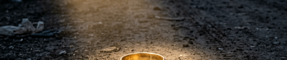 Golden ring on muddy dirt road with tents and people in background