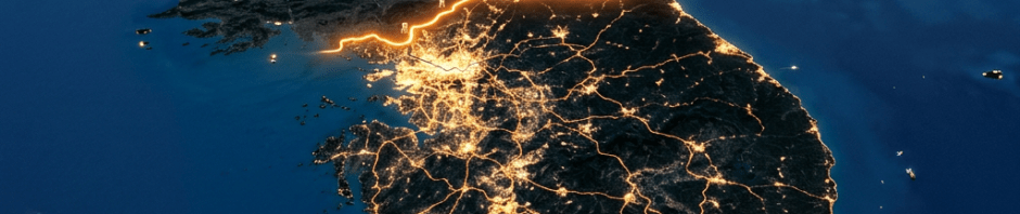Korean Peninsula at night with bright city lights in South Korea and a highlighted North Korea border