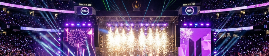 BTS performing live on stage at Allegiant Stadium with fireworks and glowing crowd