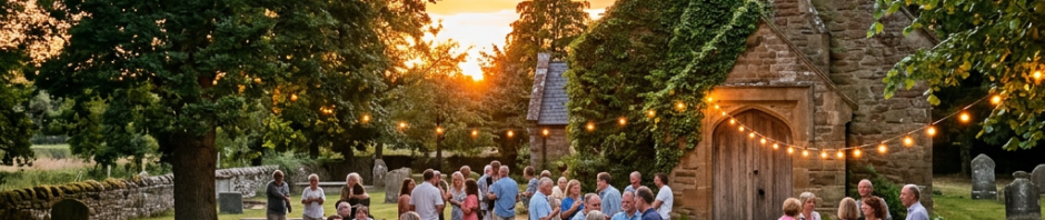 Group of people socializing outside a small church with string lights at sunset